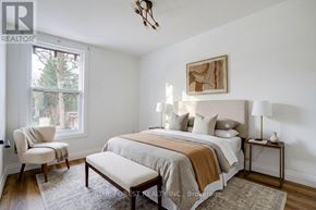 London East (East F) multi-family for rent - A bedroom with a bed, chair, and window.