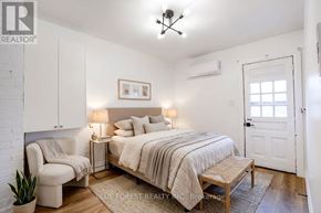 London East (East F) multi-family for rent - A bedroom with a bed, chair, and a plant.