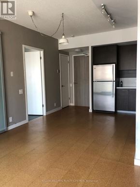 Toronto (Waterfront Communities) condo for rent - A spacious kitchen with a refrigerator, cabinets, and a countertop.