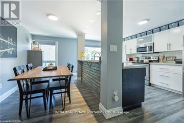 London South (South R) townhouse for rent - A kitchen with a dining table and chairs in the foreground and a kitchen in the background.
