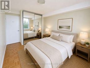 Toronto (Flemingdon Park) condo for rent - A bedroom with a large bed, a mirror, and a painting on the wall.