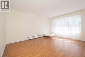 Waterloo apartment for rent - A room with wooden floors and a window with curtains.