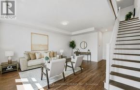 Oakville (Go Glenorchy) townhouse for rent - A living room with a white couch, a grey chair, and a wooden floor.