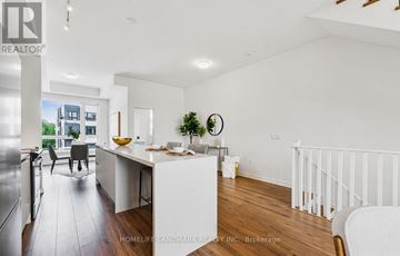 Oakville (Go Glenorchy) townhouse for rent - A white kitchen with a dining table and chairs.
