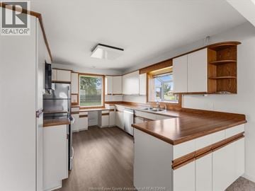 Windsor apartment for rent - A kitchen with white cabinets and a wooden counter top.