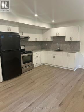 Mississauga (Clarkson) apartment for rent - A kitchen with black appliances and white cabinets.