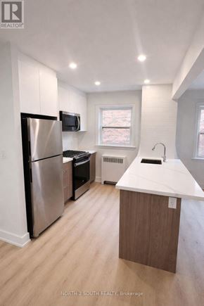 Hamilton (Stipley) multi-family for rent - A kitchen with a refrigerator, microwave, and sink.
