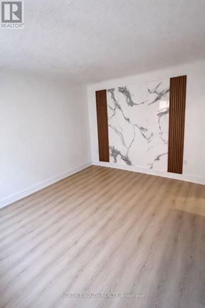 Hamilton (Stipley) multi-family for rent - A room with a marble wall and wooden flooring.