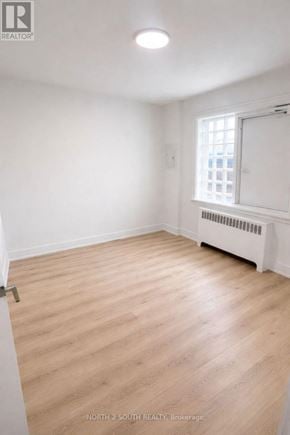 Hamilton (Stipley) multi-family for rent - A room with wooden flooring and a window with a white frame.