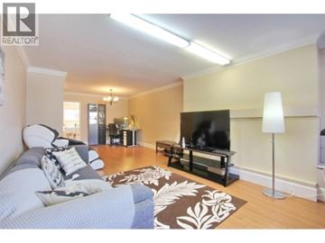Burnaby apartment for rent - A living room with a grey couch and a black television.