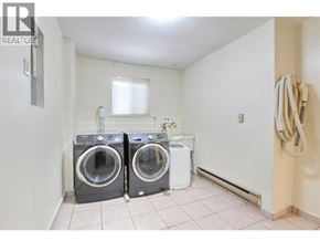 Burnaby apartment for rent - A laundry room with two washing machines and a towel rack.