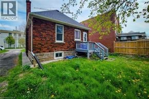 Hamilton apartment for rent - A small red brick house with a blue roof and a porch.