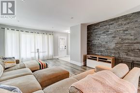 Oshawa (Donevan) apartment for rent - A living room with a stone wall and a couch.
