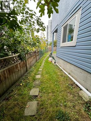 Vancouver apartment for rent - A blue house with a wooden fence and a stone pathway leading to the door.