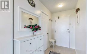 Brampton (Queen Street Corridor) condo for rent - A white hallway with a mirror and a vase of flowers on the dresser.