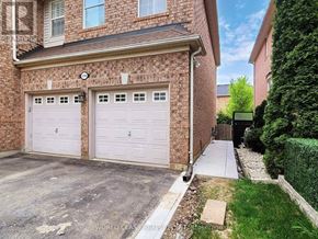 Oakville (Wm Westmount) apartment for rent - A house with a brick facade and two white garage doors.