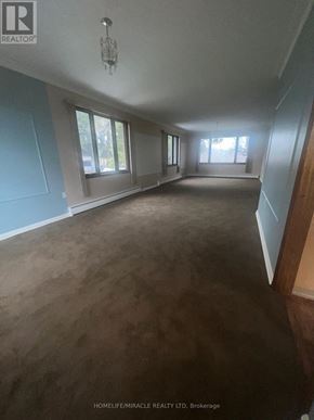Caledon (Palgrave) apartment for rent - A large empty room with a chandelier and large windows.