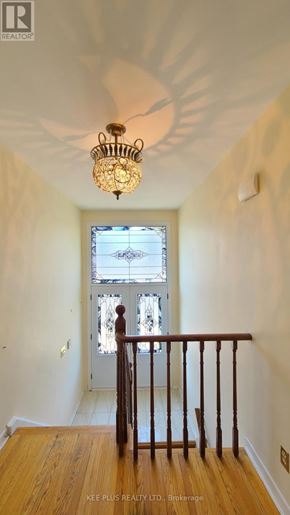 Toronto (Morningside) apartment for rent - A chandelier hangs from the ceiling in a room with a wooden floor and a window with a view of a city.
