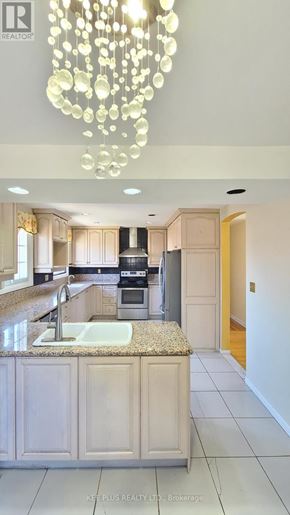 Toronto (Morningside) apartment for rent - A modern kitchen with a granite countertop and a chandelier.