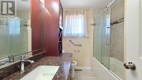 Toronto (Morningside) apartment for rent - A bathroom with a sink, mirror, and shower.