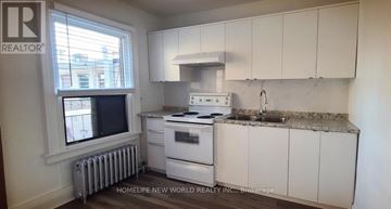 Toronto (Corso Italia-Davenport) apartment for rent - A small kitchen with white cabinets and a granite countertop.