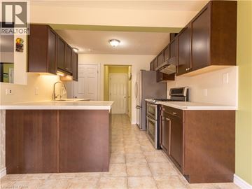 Waterloo townhouse for rent - A kitchen with brown cabinets and a white counter top.