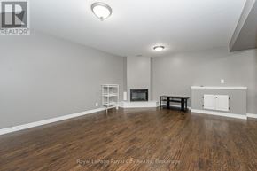 Guelph (Grange Road) apartment for rent - A spacious room with a fireplace and wooden flooring.