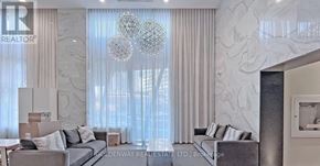 Toronto (Willowdale West) condo for rent - A living room with a grey sofa and a large window with curtains.