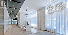 Toronto (Willowdale West) condo for rent - A spacious, well-lit room with a large chandelier and a long mirrored wall.