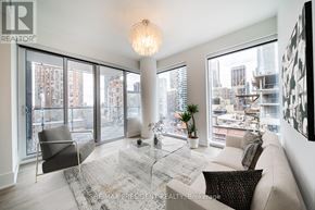 Toronto (Church-Yonge Corridor) condo for rent - A living room with a couch, chair, and a table with a plant on it.