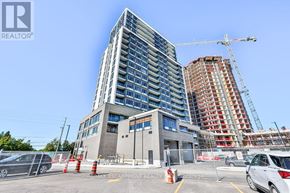 Milton (Co Coates) condo for rent - A modern building with a crane in the background and a parking lot in the foreground.