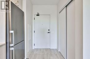 Milton (Co Coates) condo for rent - A white door is in a hallway with a refrigerator on the left.