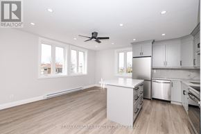 Fort Erie (Central) multi-family for rent - A spacious kitchen with white cabinets and a wooden floor.