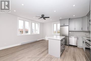 Fort Erie (Central) multi-family for rent - A spacious kitchen with white cabinets and a wooden floor.