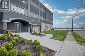 Fort Erie (Central) multi-family for rent - A modern building with a grey facade and a landscaped front yard.
