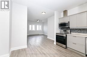 Fort Erie (Central) multi-family for rent - A kitchen with white cabinets and a stainless steel oven.