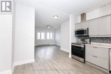 Fort Erie (Central) multi-family for rent - A kitchen with white cabinets and a stainless steel oven.