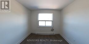 Toronto (Long Branch) apartment for rent - A room with a window and a logo that says "REALTOR" on the wall.