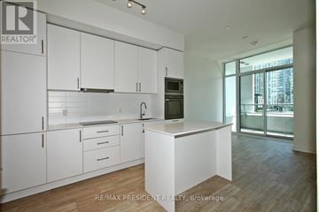 Toronto (Waterfront Communities) condo for rent - A kitchen with white cabinets and a wooden floor.
