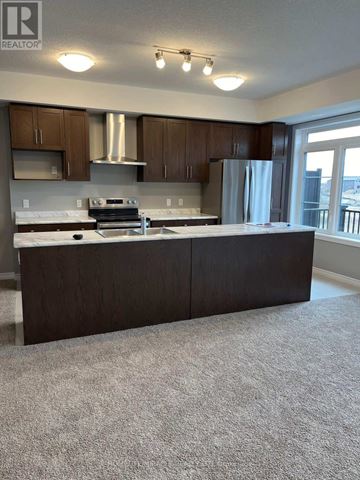 Kitchener townhouse for rent - A kitchen with a white countertop and brown cabinets.