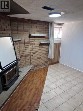 Toronto (Caledonia-Fairbank) apartment for rent - A room with a brick wall and a wood floor.