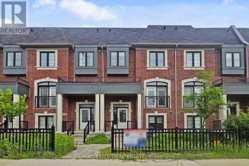 Markham (Unionville) townhouse for rent - A brick building with a black fence in front.