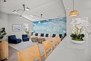 Wilmington apartment for rent - A living room with a blue couch and a large painting of a wave on the wall.