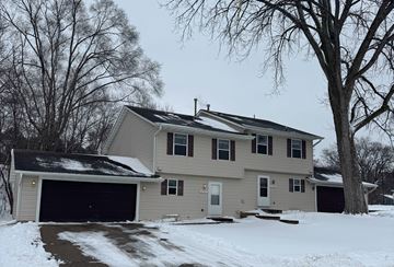 Burnsville apartment for rent - A house with a garage and a driveway covered in snow.