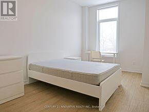Oshawa (Samac) townhouse for rent - A bedroom with a bed, a chair, and a window.