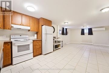 Clarence-Rockland apartment for rent - A kitchen with white appliances and wooden cabinets.