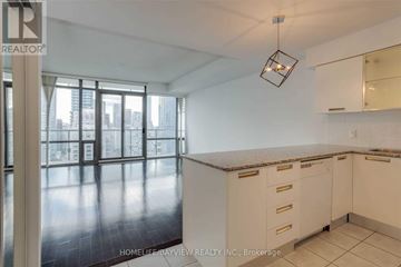 Toronto (Bay Street Corridor) condo for rent - A kitchen with white cabinets and a large window.