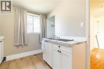 Kitchener apartment for rent - A small, clean, and well-lit kitchen with white cabinets and a window.