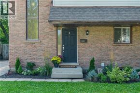 Kitchener apartment for rent - A house with a black front door and a small garden in front.