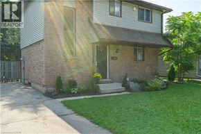 Kitchener apartment for rent - A house with a realtor sign in the front yard.